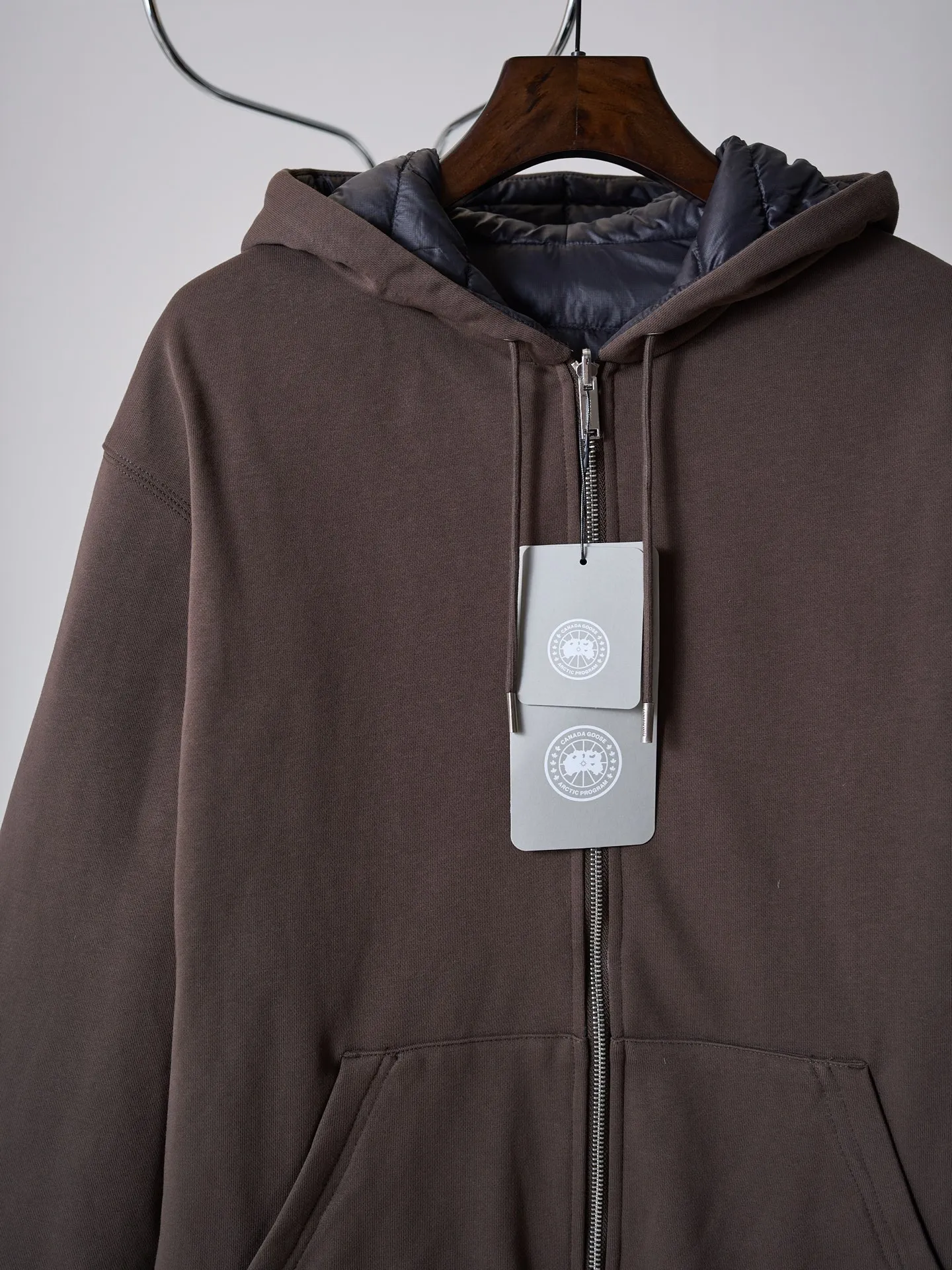 [Real object hanging] Canada Goose/Canada Goose reversible hooded down jacket [In Stock] S M L Fabric selection: The A side is made of high-quality cotton thick terry cloth. The fabric texture is fine and thick, soft and skin-friendly. It has good Breathable performance and is comfortable for daily wear. The cloth surface has been carefully finished and is not prone to pilling and deformation. The B side is made of matte tear-resistant nylon fabric, with a low-key matte texture on the surface. It has excellent tear resistance and windproof properties. The fabric is light and not bulky, and has excellent velvet resistance. The fabric tightly locks the inner down, taking into account both lightweight and practicality. The two fabrics have a sharp contrast in style, allowing you to switch between different outfits at will. Filling: The inside is filled with 90% white duck down, which weighs about 140g. It has strong heat storage and temperature locking capabilities and is evenly distributed in the compartments of the body. It is light and does not weigh down the body, saying goodbye to heavy and bloated clothes. Sewing process: Adopt double-layer independent cutting piece alignment sewing process. The inner and outer sides are cut separately, and the length, shoulder line, and hat shape are accurately aligned. The edges are processed with seamless overlocking to avoid misalignment and twisting problems between the two layers of fabric. The horizontally divided down locking lines are neat and stable, effectively fixing the down and preventing the down from shifting and forming a ball. The entire garment has multiple reinforcements at the joints, taking into account the aesthetics of wearing it on both sides. No unnecessary messy stitches can be seen on the front and back, achieving a clean look on both sides. Details: Equipped with elastic rib cuffs and hem, with moderate elasticity, it closely fits the wrist and waist and abdomen, blocking the intrusion of cold wind. The A-side hood is equipped with a metal engraved hood rope, which can be freely adjusted for tightness, and is equipped with a Classic kangaroo pocket for convenient storage; the B-side is equipped with a zipper opening and closing pocket, the zipper is smooth and durable, and meets outdoor storage needs; the side of the sleeve is embellished with a circular embroidered logo, and multiple layers of embroidery thread create a three-dimensional logo, which enhances product recognition in a low-key manner.